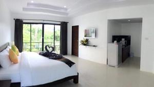 a bedroom with a large bed and a large window at The Seashore Kamala Service Apartment in Kamala Beach