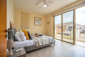 a bedroom with a bed and a large window at Mambo Private Villa with Pool by the Beach in Paralimni