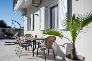 a patio with a table and chairs and a potted plant at Memoa Residence Preveza in Preveza