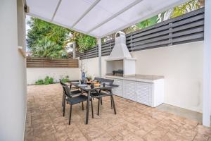 a patio with a table and chairs and a kitchen at Mambo Private Villa with Pool by the Beach in Paralimni