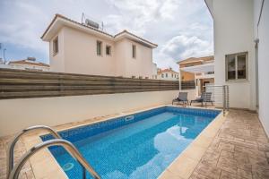 a villa with a swimming pool and a house at Mambo Private Villa with Pool by the Beach in Paralimni