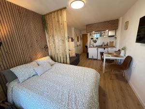 a bedroom with a white bed and a kitchen at Tamy-Home in Empuriabrava
