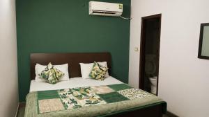 ein Schlafzimmer mit einem Bett und einer grünen Wand in der Unterkunft Hotel The Height in Chandīgarh