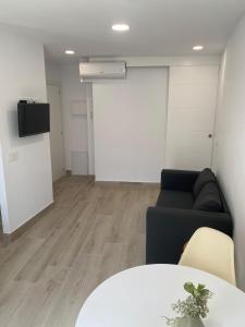 a living room with a couch and a table at Apartamento centro Cubelles in Cubelles