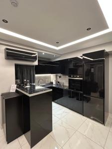 a kitchen with black cabinets and black counters at The Absolute Luxury Apartment in Kalamata