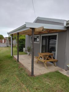 a picnic shelter with a picnic table in a yard at GOOSE Nest in Gonubie