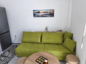 a green couch in a living room with a table at Mok's House in Kavála