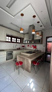 a large kitchen with red chairs and a large island at Casa Aparecida in Aparecida +12 photos
