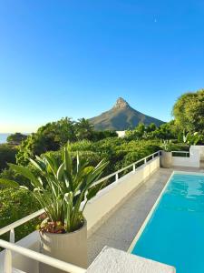 a villa with a pool and a mountain in the background at Bay Reflections Camps Bay Luxury Serviced Apartments in Cape Town