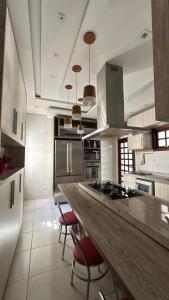 a kitchen with a large counter with red bar stools at Casa Aparecida in Aparecida