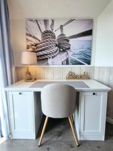 a desk with a chair and a picture on the wall at Ferienhaus Oberhüs - Das Familien-Ferienhaus an der Ostsee in Scharbeutz