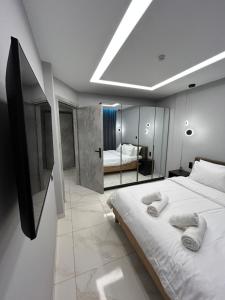 a bedroom with a large bed with towels on it at The Absolute Luxury Apartment in Kalamata