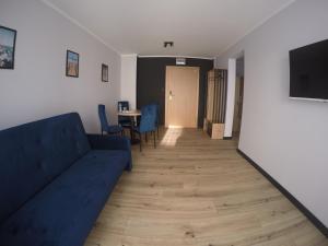 a living room with a blue couch and a table at Baltic Stay in Władysławowo