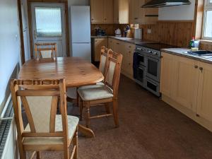 a kitchen with a wooden table and chairs at Rousay&nbspCottage in Orkney