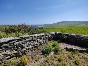 an old stone wall on the side of a field at Lower Cottage in Orkney
