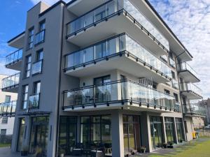 an apartment building with balconies and glass windows at Baltic Stay in Władysławowo