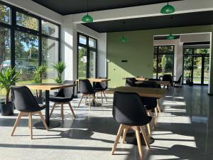 a cafeteria with tables and chairs and windows at Baltic Stay in Władysławowo