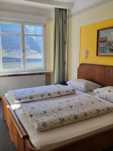 three beds in a room with a window at Hotel Mosel-Landhaus in Briedern