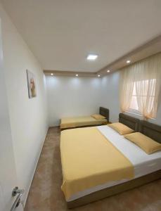 a bedroom with three beds and a window at Vila Ideal in Donji Štoj