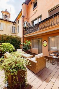 a patio with a couch and chairs on a wooden deck at Como Icon Centro Apartment By Icon7 Luxury in Como