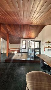 a room with a wooden ceiling with a table and chairs at Casa Aparecida in Aparecida