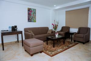 ein Wohnzimmer mit zwei Sofas und einem Tisch in der Unterkunft Sinkor Palace Hotel in Monrovia
