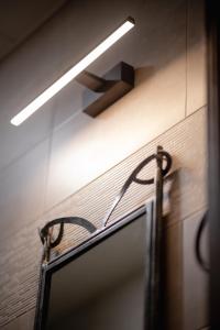 a bathroom with a light on the wall and a mirror at Golden Boutique Hotel in Tbilisi City +38 photos