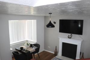 a living room with a fireplace and a tv on the wall at The Wigmore house in Luton