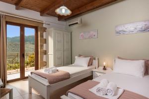 two beds in a room with a balcony at Villa Gianna by PosarelliVillas in Fílippos +46 photos