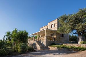 a house on a hill with palm trees in front of it at Villa Gianna by PosarelliVillas in Fílippos