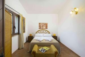 a bedroom with a bed and a chair in it at Panoramic Seaview Coastal Retreat with Pool in Cugnana +123 photos