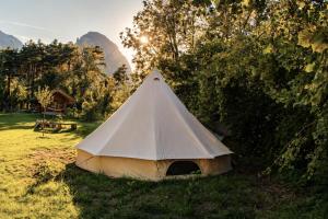 a white tent in a field with mountains in the background at WoodMood in Leuk