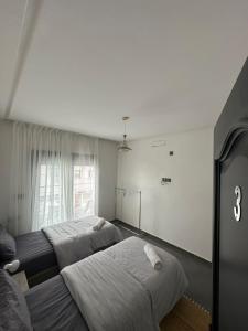 two beds in a room with a window at Wavera Surf Camp in Imsouane
