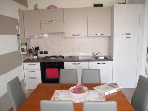 eine Küche mit einem Tisch und einer Schüssel Blumen darauf in der Unterkunft In vacanza da Miki 01 in Desenzano del Garda