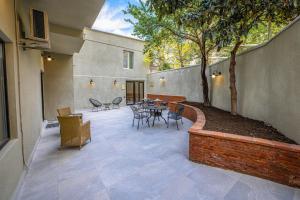 a patio with a table and chairs and a tree at Golden Boutique Hotel in Tbilisi City