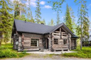 a log cabin with a black roof at Vacation home 'Örtsylä A' in Salla