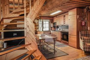 a kitchen with wooden cabinets and a table in a room at Vacation home 'Örtsylä A' in Salla