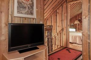 a living room with a television and a bedroom at Vacation home 'Örtsylä A' in Salla