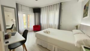 a white hotel room with a bed and a desk at Hotel Gabriel y Galán in Salamanca