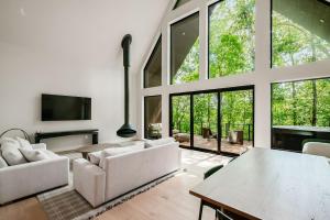 a living room with white furniture and large windows at Highpoint in New Plymouth