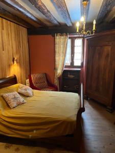 a bedroom with a bed and a chair at La Régalade, Pyrénées in Sorgeat