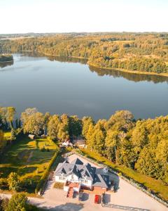 an aerial view of a house with a lake at Królowa Kaczek - własna plaża, pomost, sauna z widokiem na wodę i sala warsztatowa in Sorkwity