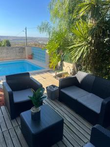 a patio with two couches and a swimming pool at Torres Vedras House in Silveira