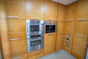 a kitchen with wooden cabinets and stainless steel appliances at Torres Vedras House in Silveira