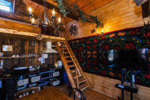 a living room with a wooden wall and a ladder at Cabana Vatra Plaiului in Şarul Dornei +2 photos