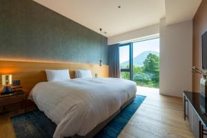 a bedroom with a large bed and a large window at Intuition in Kutchan