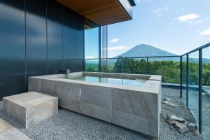 a glass house with a hot tub with a view at Intuition in Kutchan