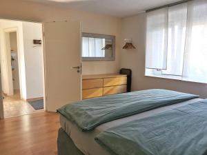 a bedroom with a bed and a dresser and a mirror at Ferienwohnung im Erdgeschoss direkt am Rad- und Spazierweg in Silz