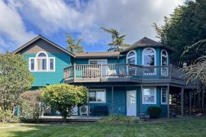 a blue house with a deck and a balcony at Driftwood Hideaway in Indian Beach