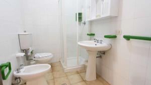 a white bathroom with a toilet and a sink at Residenza Pierre & Vacances Luni Mare in Luni